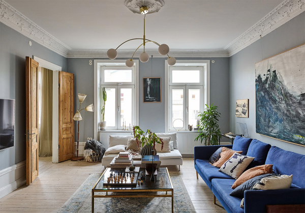 Просторная шведская квартира с синим диваном и винтажными деталями
