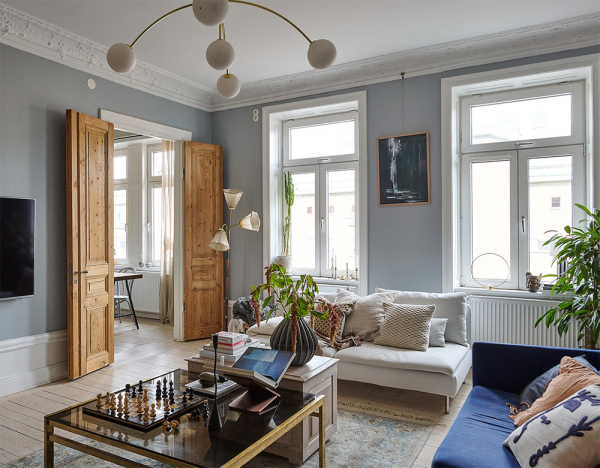 Просторная шведская квартира с синим диваном и винтажными деталями