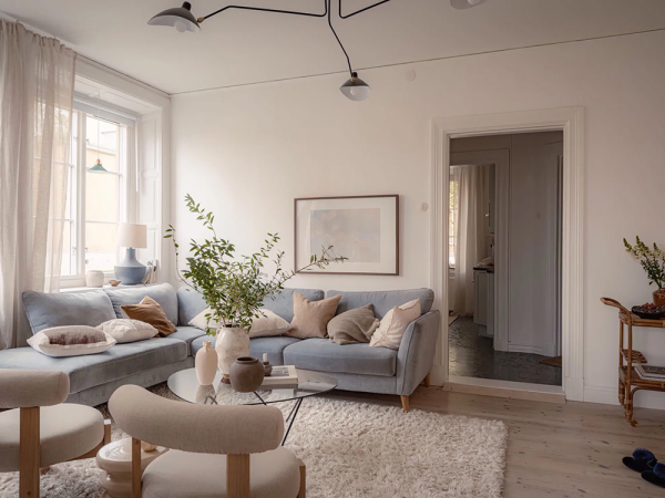 Пастельно-голубой диван и много текстиля: мягкий интерьер в Швеции (61 кв. м)